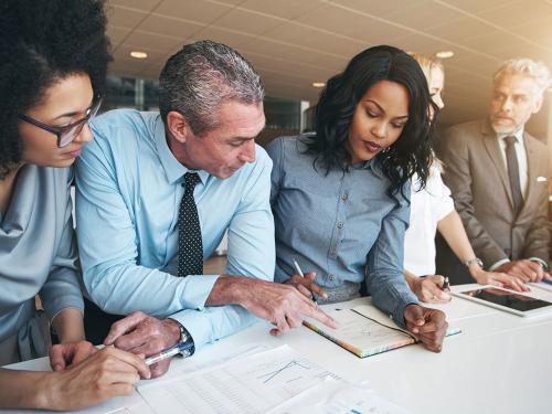 Black and white group of people doing teamwork in contemporary office.