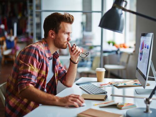 Modern designer sitting in front of computer in office